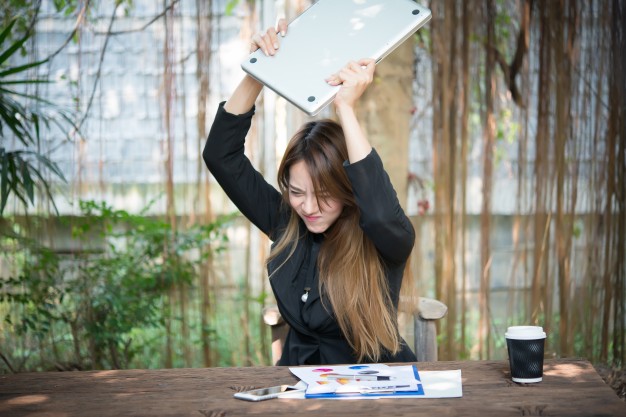 woman throwing her laptop down with password rage